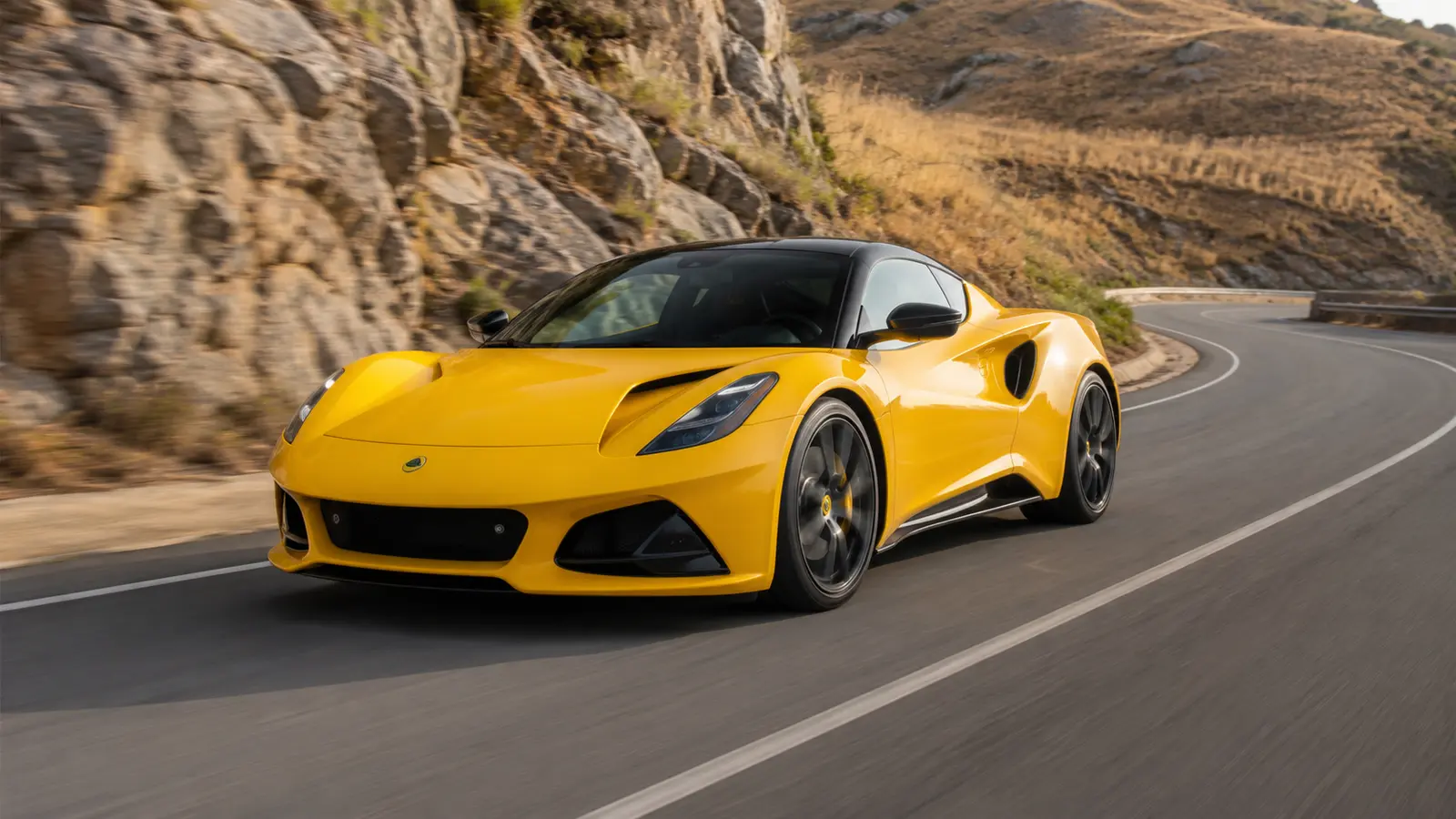 АВТО 1000296 жёлтый Lotus Emira V6 на горной дороге