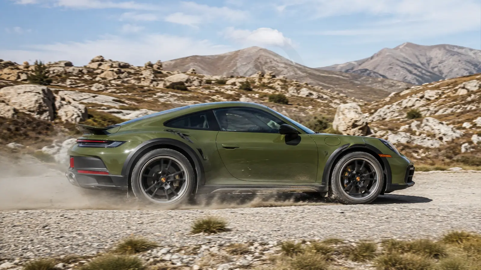 АВТО 1000805 зелёный Porsche 911 Dakar на гравийной дороге